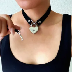 Mulher usando a gargantilha choker preta com cadeado de coração e segurando a chave
