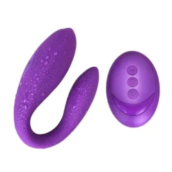Vibrador de casal em U roxo ao lado do controle remoto oval