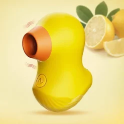 Vibrador patinho amarelo sugador de clitóris com bico laranja ao lado de limões