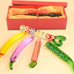 Dildos de vidro coloridos em forma de banana, berinjela, rabanete e pepino com a caixa