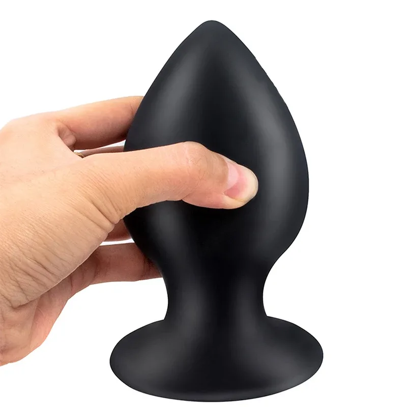 Dedos apertando o plug anal de silicone para mostrar que ele cede pouco e volta ao formato
