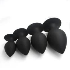 Plugs anais de silicone preto em quatro tamanhos alinhados para comparação
