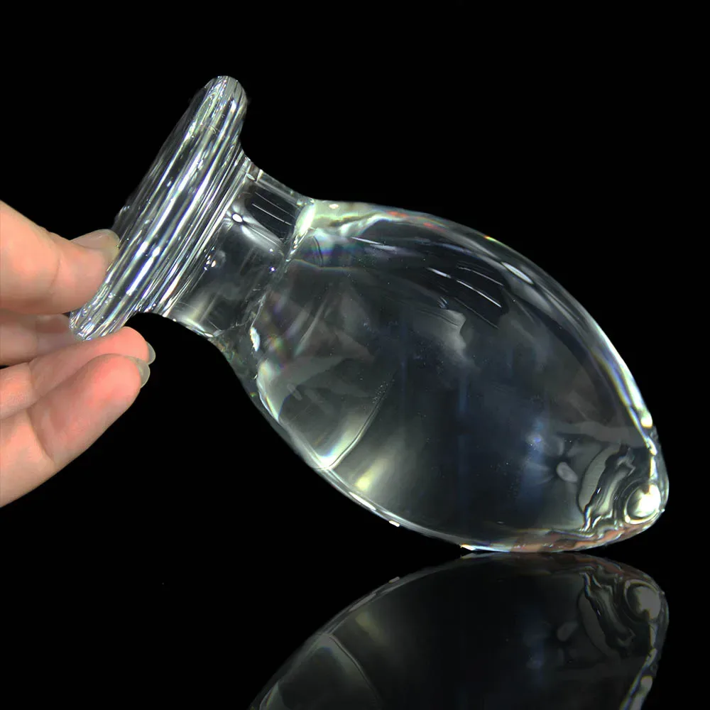 Glass butt plug oval segurado pela base contra fundo preto