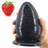 Plug anal grande Big Berry em formato de morango preto na mão