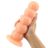 Mãos segurando o plug anal de cinco bolas cor pele clara, mostrando o tamanho