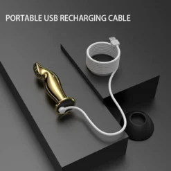 Plug anal vibratório dourado ligado ao cabo de recarga USB