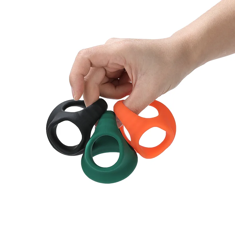 Mão segurando os três anéis penianos, preto, verde e laranja