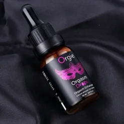 Frasco de 15 ml do Orgie Orgasm Drops sobre tecido preto
