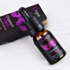 Frasco do Orgie Orgasm Drops deitado sobre a caixa