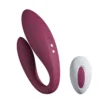Vibrador de casal Cúmplice roxo vinho em formato U ao lado do controle remoto sem fio