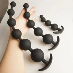 Plug anal beads de silicone preto em dois tamanhos sobre a mão