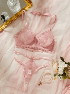 Conjunto de lingerie rosa com sutiã de renda, calcinha fio dental e choker com coração