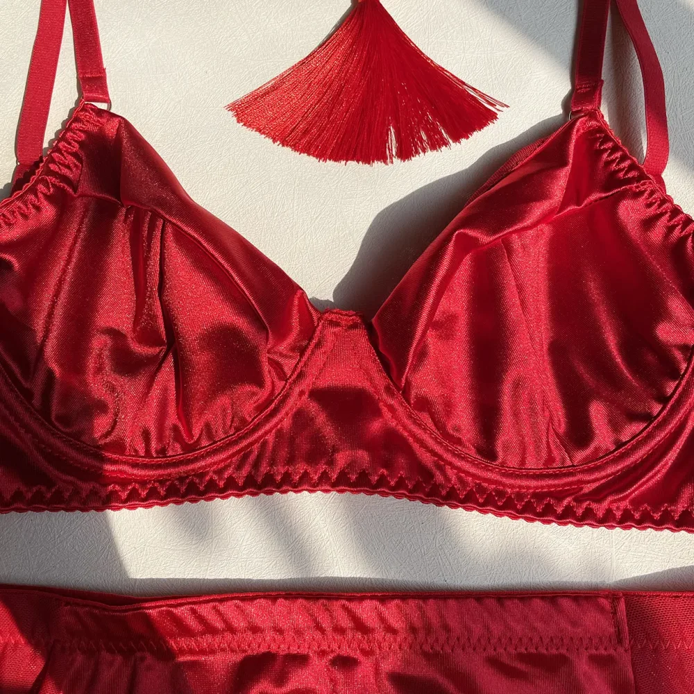 Detalhe do sutiã de aro em cetim vermelho com acabamento de renda