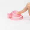 Cinto de castidade macia rosa transparente sendo pressionado com o dedo