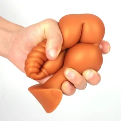 Contas do plug anal longo sendo apertadas na mão, mostrando o silicone macio e flexível