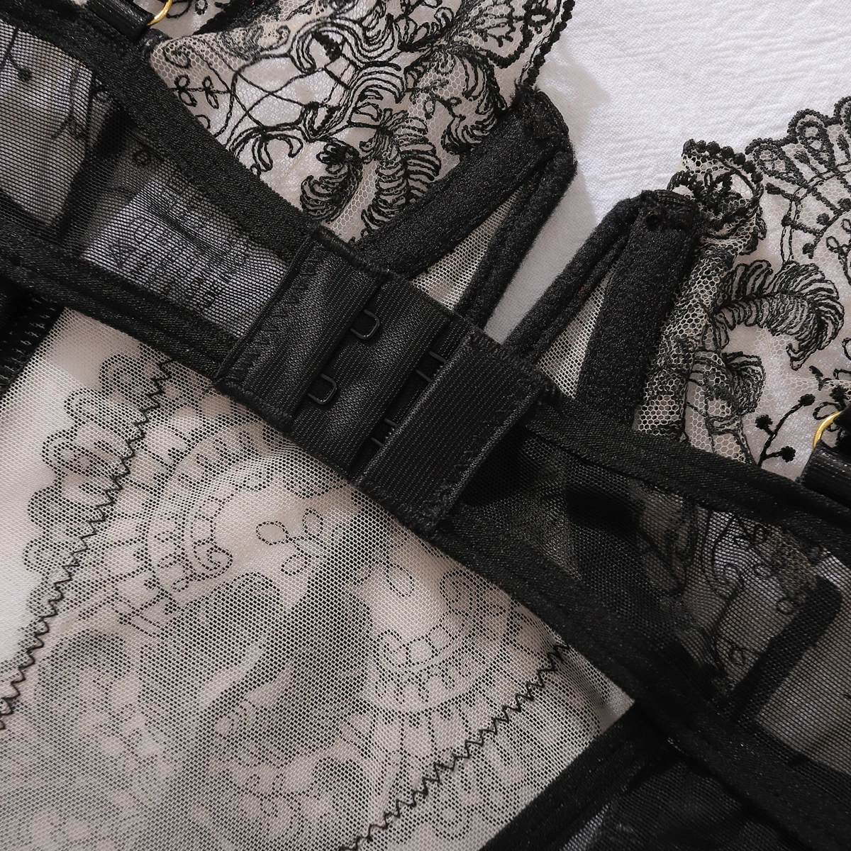 Detalhe do colchete de fechamento nas costas e da tira de cinta-liga do corset bustier