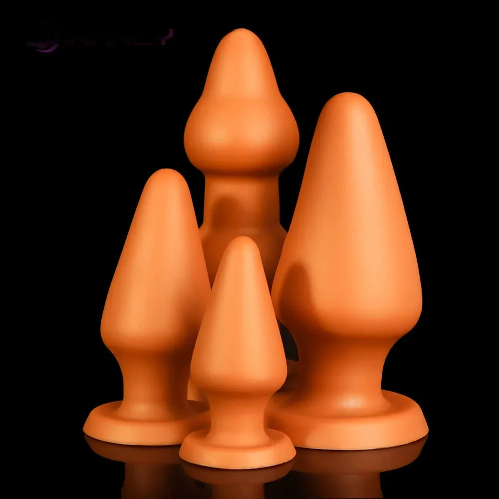 Três plugs anais gigantes em cone dourado nos tamanhos pequeno, médio e grande lado a lado