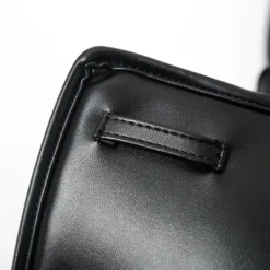 Detalhe do passante costurado na capa acolchoada, por onde a tira de couro atravessa