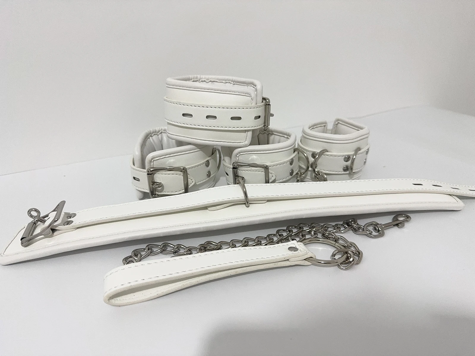 Kit bondage branco acolchoado completo com coleira, guia, algemas e tornozeleiras em couro PU e metal cromado