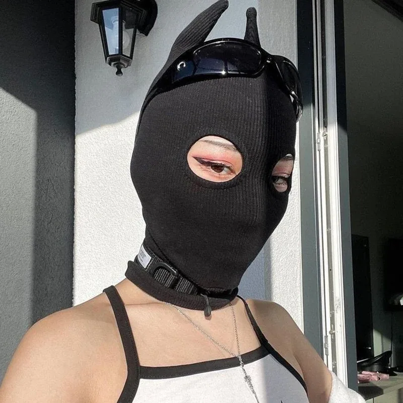 Balaclava com chifres de demônio usada com óculos escuros apoiados na cabeça