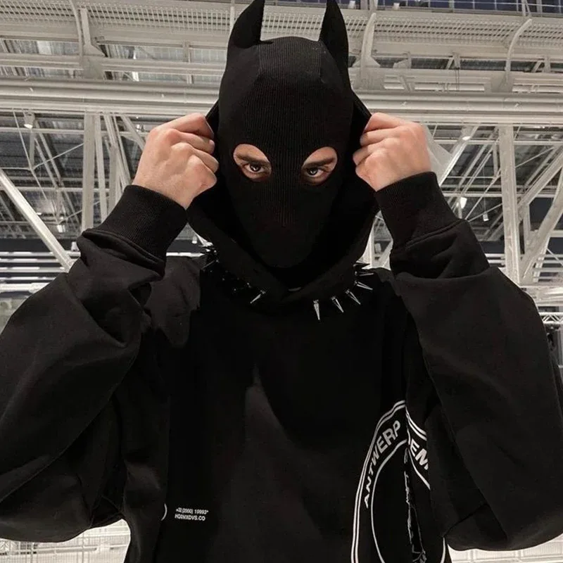 Modelo vestindo a balaclava com chifres em look streetwear com coleira de spikes