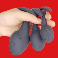 Os três tamanhos do plug anal iniciante Black Drop na mão para comparar a escala