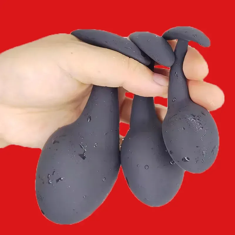 Os três tamanhos do plug anal iniciante Black Drop na mão para comparar a escala