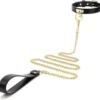 Coleira preta de couro sintético com O-ring dourado e guia de corrente dourada com alça de couro