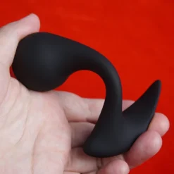 Plug anal de próstata base T: plug anal de próstata na mão mostrando a haste curvada